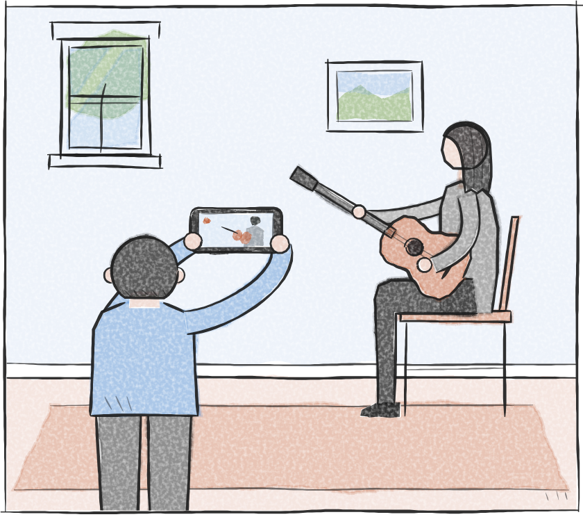 A child, seen from behind, holds up a phone to film Luke playing guitar.